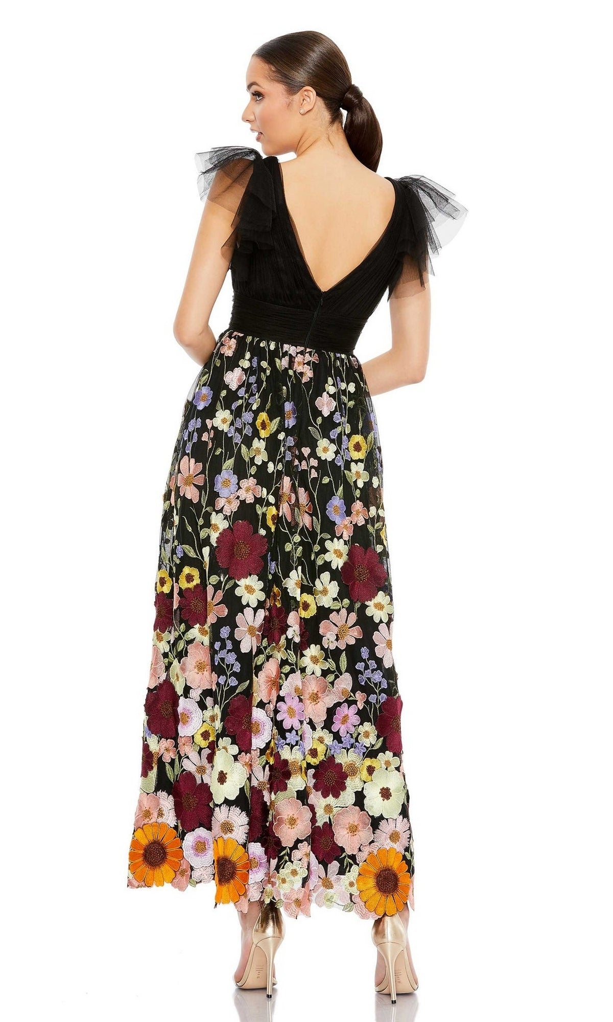 Woman wears the Mac Duggal 68204 tea-length floral formal dress with ruffled tulle sleeves, standing with her back to the camera and her hair in a ponytail.